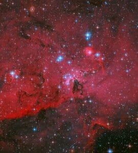 NASA's Hubble Captures Crimson Cloud Sparkling with White, Blue Stars