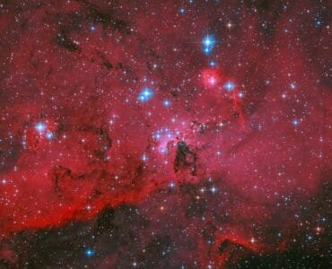 NASA's Hubble Captures Crimson Cloud Sparkling with White, Blue Stars